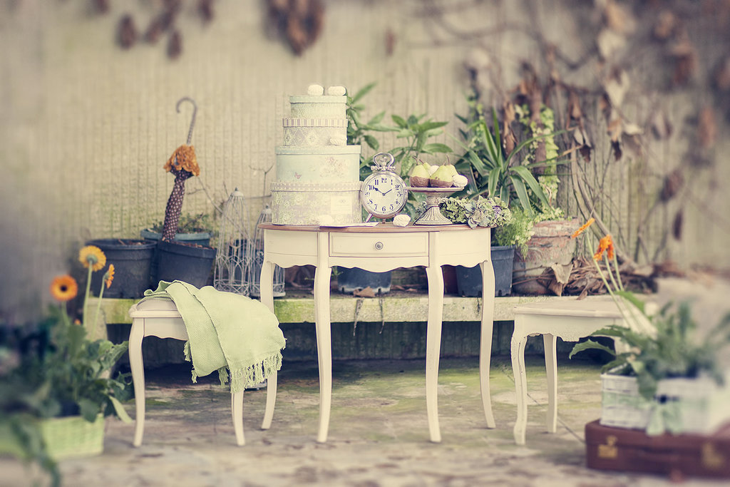 Bela tronadstropna poročna torta ter sladice na prekrasni starinski mizi, postavljeni ob bok dveh manjših mizic s cvetlično dekoracijo. Foto: arhiv Storija weddings
