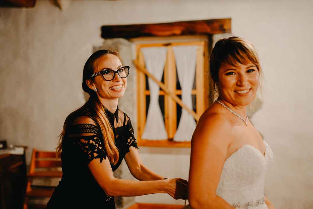 Top organizator porok Petra Starbek pomaga nevesti pri njeni poročni obleki pred prvim plesom. Foto: Moj Fokus Photography