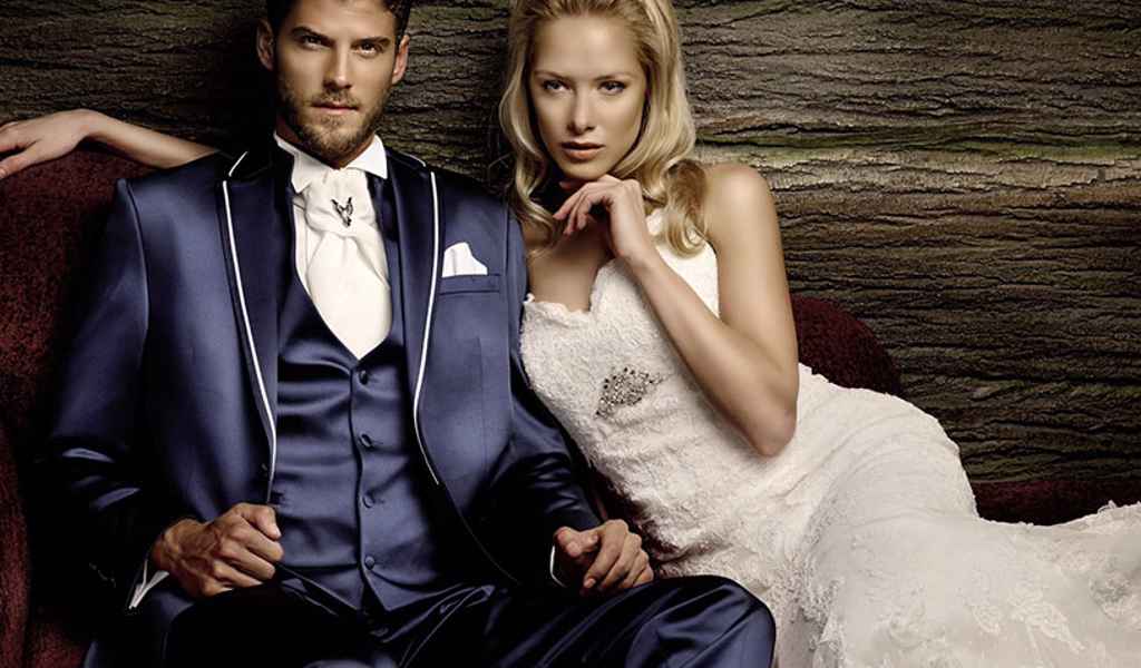 Ženin v modri svečani poročni obleki ter nevesta v čipkasti obleki iz salona Karizma v Ljubljani. Foto & vir: Karizma, poročna oblačila