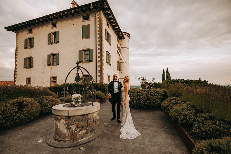 Nevesta v poročni obleki znamke Berta in ženin v obleki Hugo Boss stojita pred vodnjakom hotela Gredič, ki je njuna poročna lokacija. Organizator porok je poskrbel, da je vsak detajl urejen po njunih željah, kot tudi dekoracija na vodnjaku, blago iz hotelskih oken ter cvetje na travi.