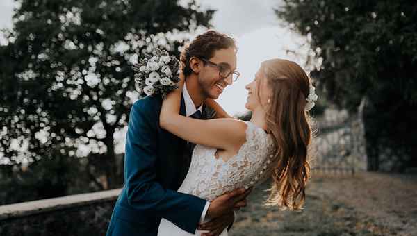 Par med poročnim fotografiranjem v Ferarrijevem vrtu v Štanjelu. Par se zaljubljeno gleda in uživa v druženju v objemu neokrnjene narave. Za organizacija poroke skrbi Petra Starbek.